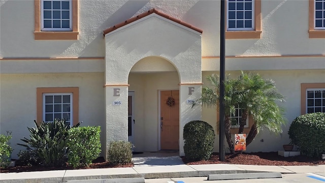 doorway to property featuring stucco siding