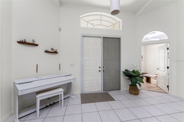 tiled foyer entrance featuring ceiling fan and high vaulted ceiling