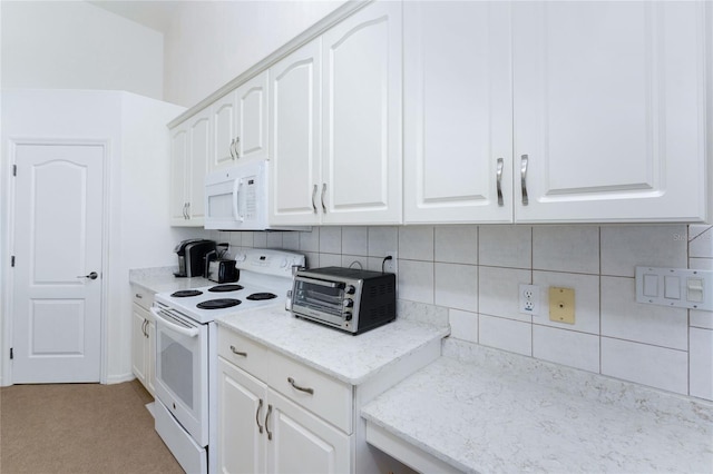 kitchen featuring tasteful backsplash, white cabinetry, light stone countertops, and white appliances