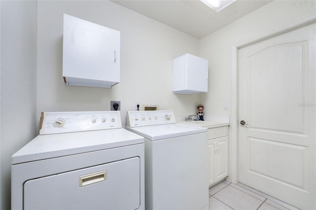 laundry room featuring cabinets, washing machine and dryer, light tile patterned floors, and sink