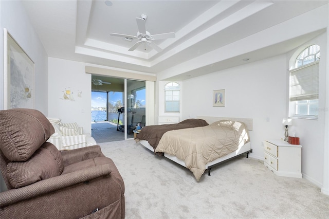 bedroom featuring access to exterior, ceiling fan, light carpet, and multiple windows