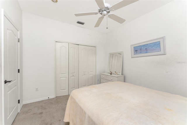 bedroom with ceiling fan, light carpet, and a closet