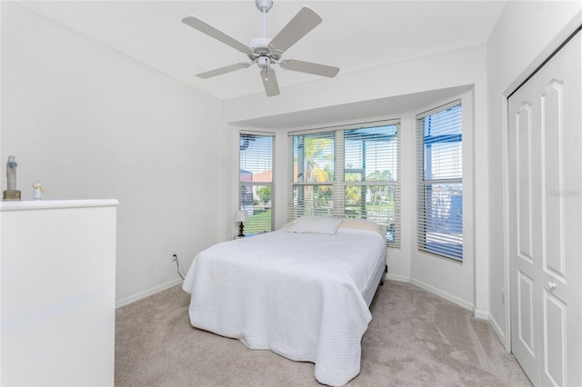 carpeted bedroom featuring a closet and ceiling fan