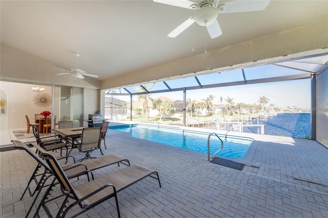 view of pool with glass enclosure, ceiling fan, and a patio