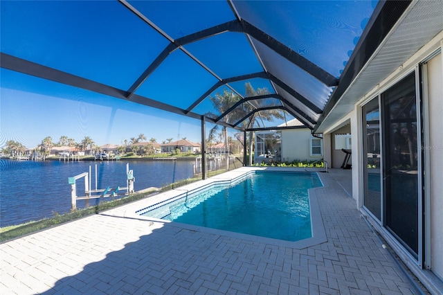 view of pool with glass enclosure, a dock, a water view, and a patio