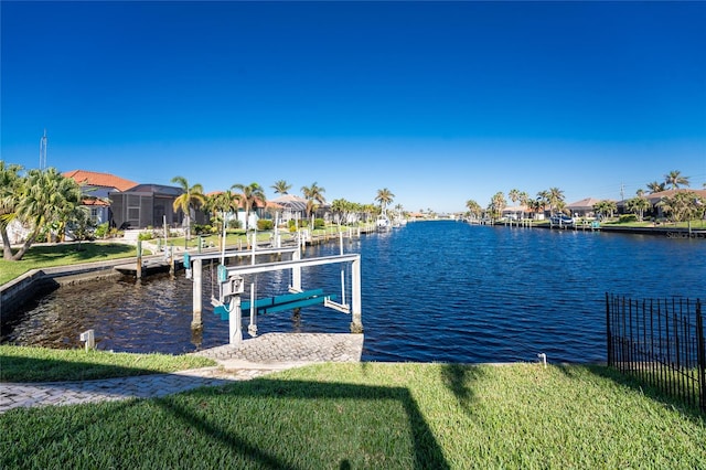 dock area featuring a water view and a lawn