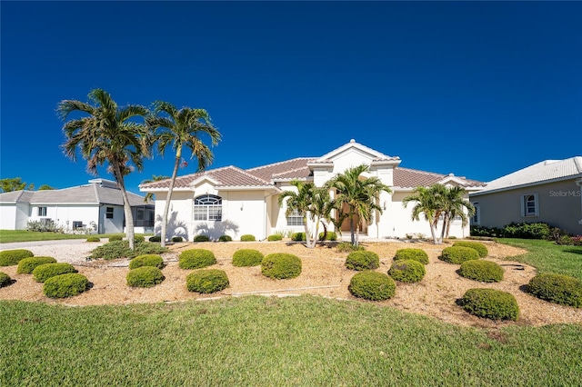 mediterranean / spanish home featuring a front yard