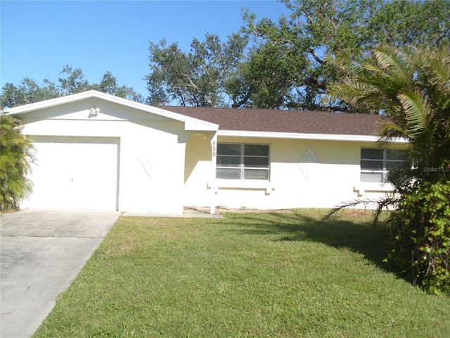 ranch-style home with a garage and a front lawn