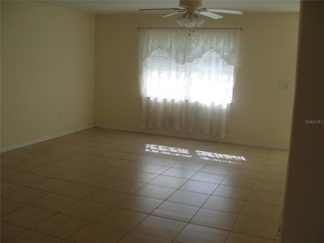 empty room with ceiling fan and light tile patterned flooring