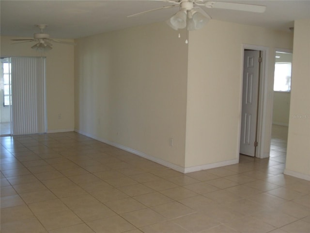 tiled empty room featuring ceiling fan