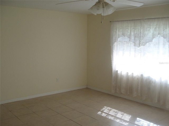 tiled empty room featuring ceiling fan