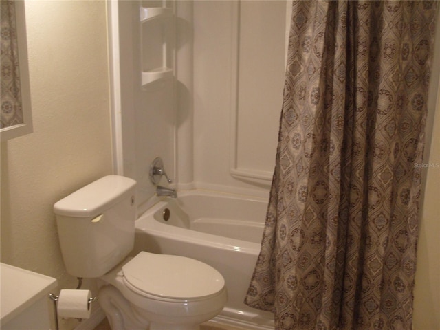 bathroom featuring shower / tub combo and toilet