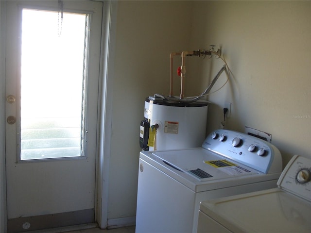 washroom featuring water heater and washing machine and clothes dryer