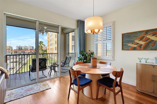 dining area with a notable chandelier, a healthy amount of sunlight, and light wood-type flooring