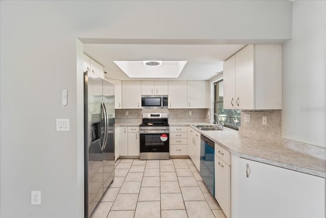 kitchen with white cabinetry, sink, tasteful backsplash, light tile patterned floors, and appliances with stainless steel finishes