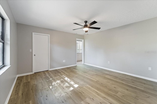 empty room with ceiling fan and light hardwood / wood-style floors