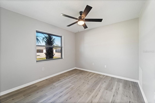 empty room featuring ceiling fan, light hardwood / wood-style floors, and a textured ceiling