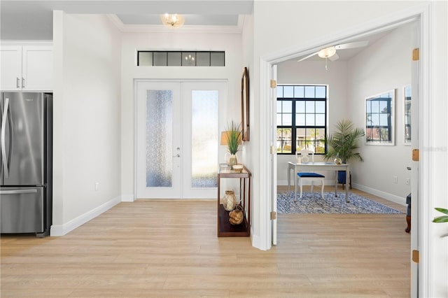 entryway featuring ceiling fan, ornamental molding, light hardwood / wood-style flooring, and french doors