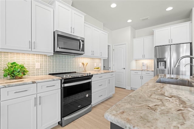 kitchen with white cabinets, appliances with stainless steel finishes, and sink