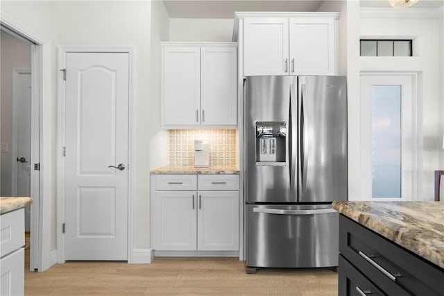 kitchen with decorative backsplash, white cabinets, stainless steel refrigerator with ice dispenser, and light wood-type flooring