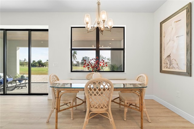 dining space featuring light hardwood / wood-style flooring and an inviting chandelier