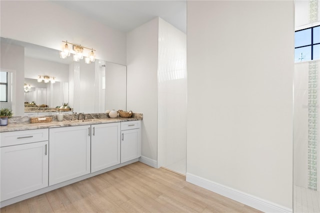 bathroom featuring a shower, hardwood / wood-style floors, and vanity