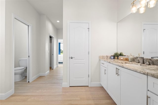 bathroom with toilet, vanity, and hardwood / wood-style flooring