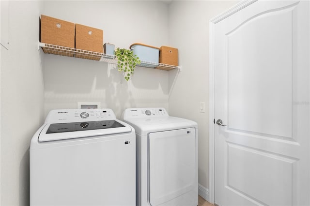 clothes washing area with washing machine and dryer