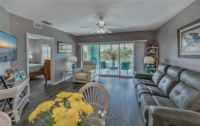 living room featuring ceiling fan and dark wood-type flooring