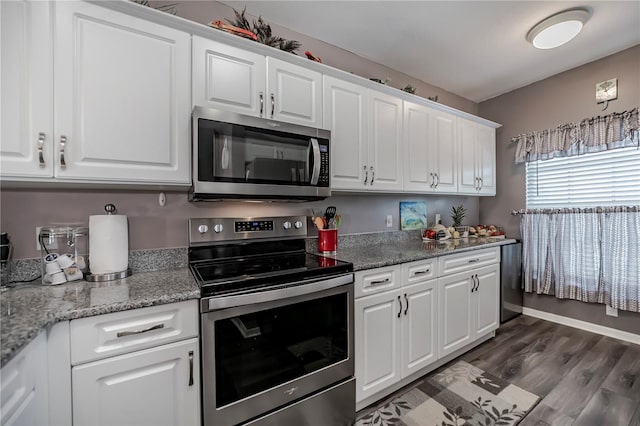 kitchen featuring white cabinetry, dark wood-type flooring, light stone counters, and appliances with stainless steel finishes