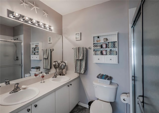 bathroom featuring a shower with door, vanity, and toilet