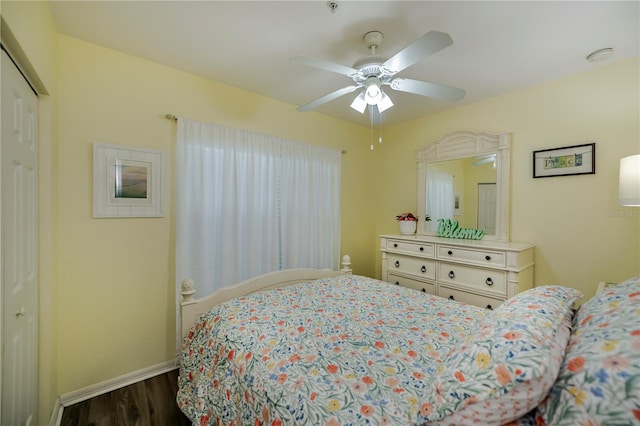 bedroom with dark hardwood / wood-style flooring, ceiling fan, and a closet