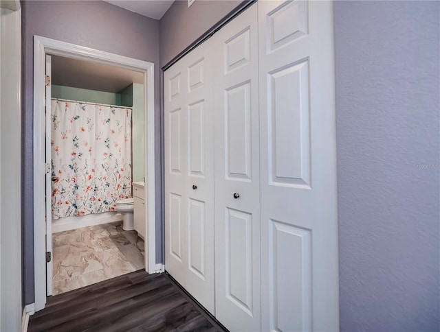 bathroom featuring a shower with shower curtain, hardwood / wood-style floors, and toilet