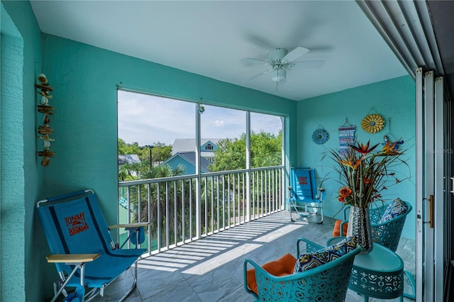 sunroom featuring ceiling fan