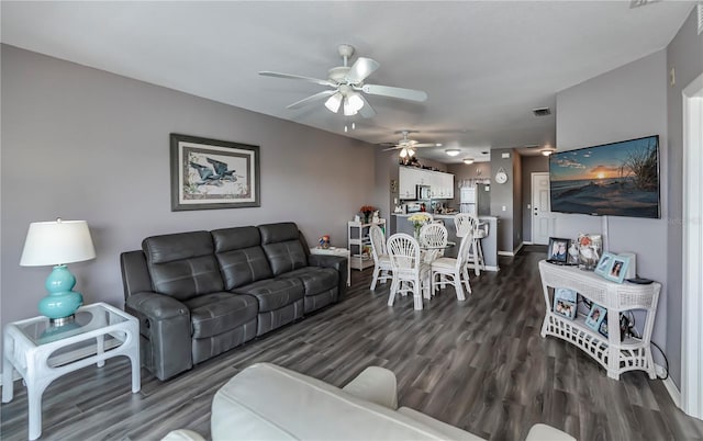 living room featuring ceiling fan and dark hardwood / wood-style flooring