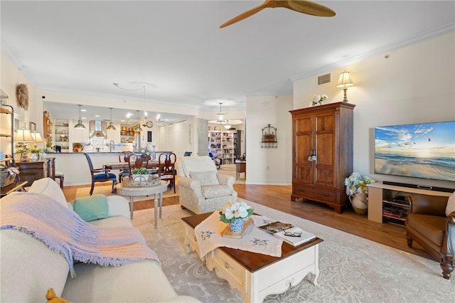 living room with light hardwood / wood-style flooring and ornamental molding