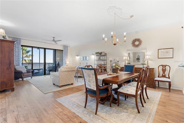 dining room with ceiling fan with notable chandelier, ornamental molding, and light hardwood / wood-style flooring