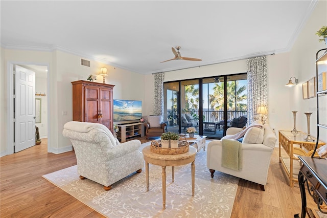 living room with ceiling fan, light wood-type flooring, and crown molding