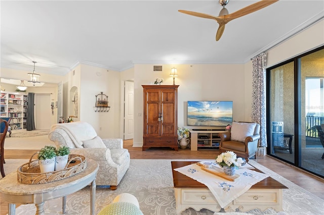 living room with light wood-type flooring, ceiling fan, and crown molding