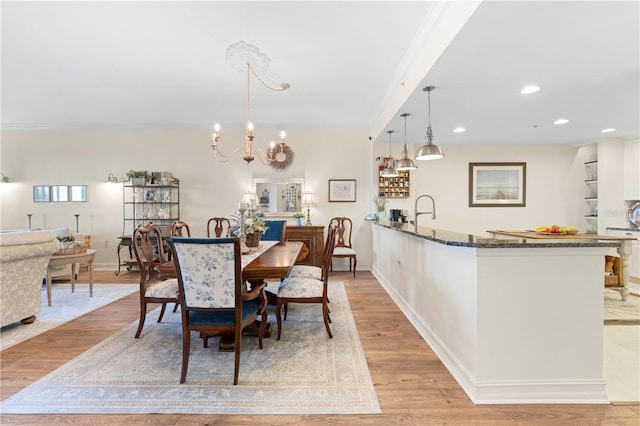 dining area featuring a chandelier, light hardwood / wood-style floors, and ornamental molding