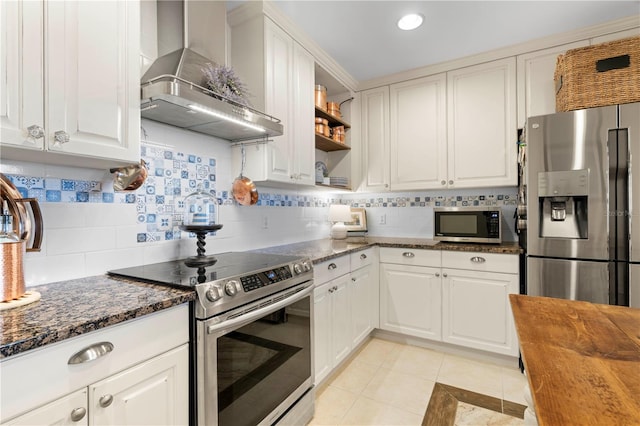 kitchen featuring wall chimney exhaust hood, white cabinetry, stainless steel appliances, and light tile patterned floors