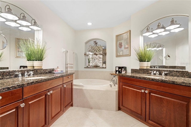 bathroom featuring tile patterned floors, vanity, and tiled tub