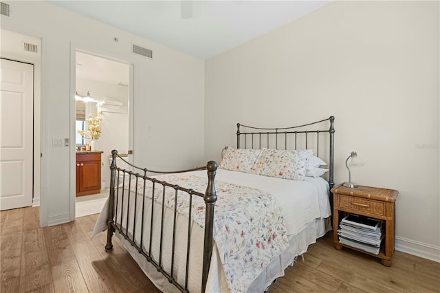 bedroom with connected bathroom, ceiling fan, and hardwood / wood-style floors