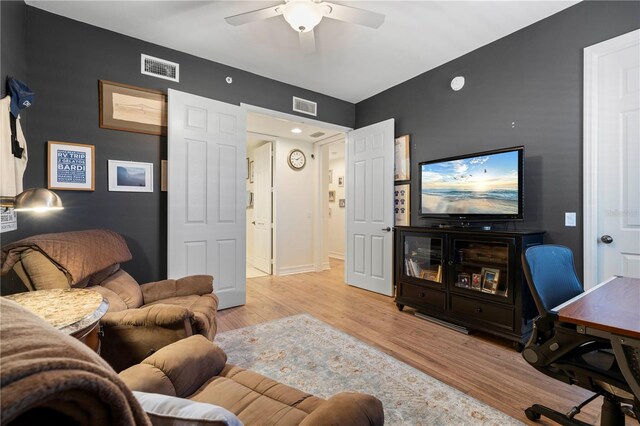 living room with ceiling fan and light hardwood / wood-style flooring