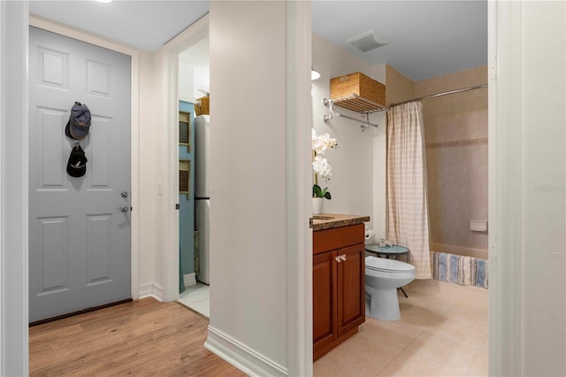 full bathroom with wood-type flooring, vanity, toilet, and shower / bathtub combination with curtain