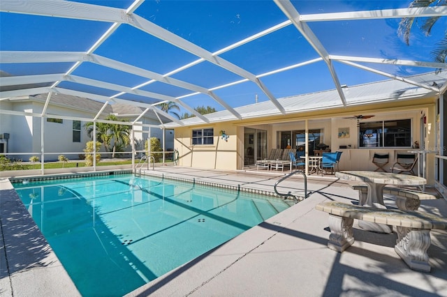 view of swimming pool featuring ceiling fan, a patio area, and a lanai