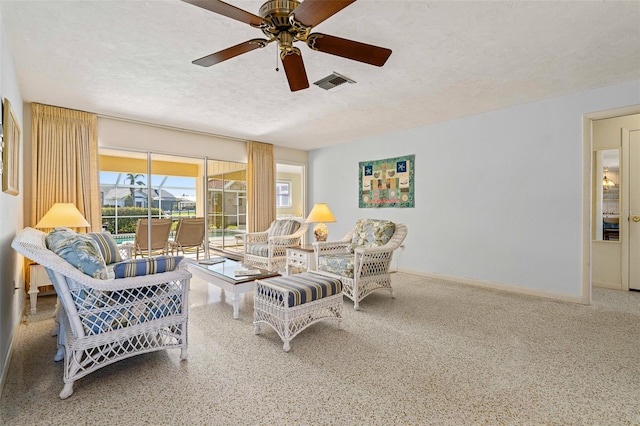 living room with a textured ceiling and ceiling fan