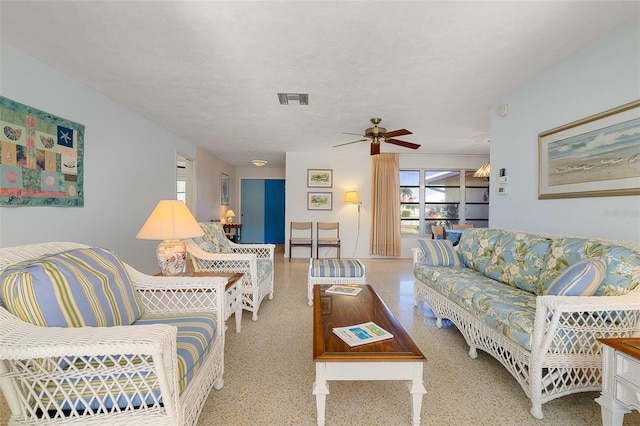 living room with a textured ceiling and ceiling fan