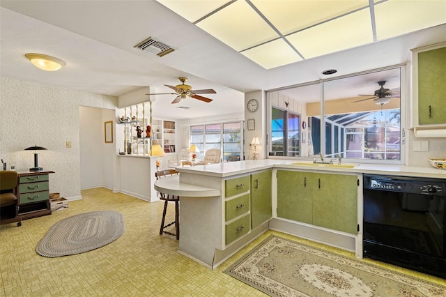 kitchen with dishwasher, a breakfast bar, sink, green cabinetry, and kitchen peninsula