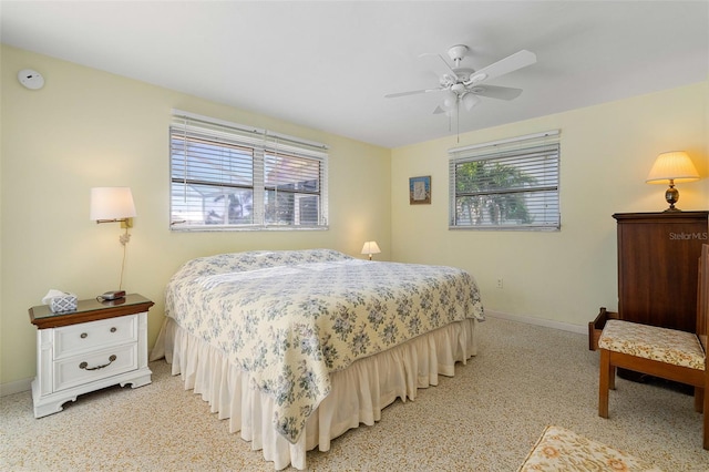 bedroom featuring light colored carpet, multiple windows, and ceiling fan